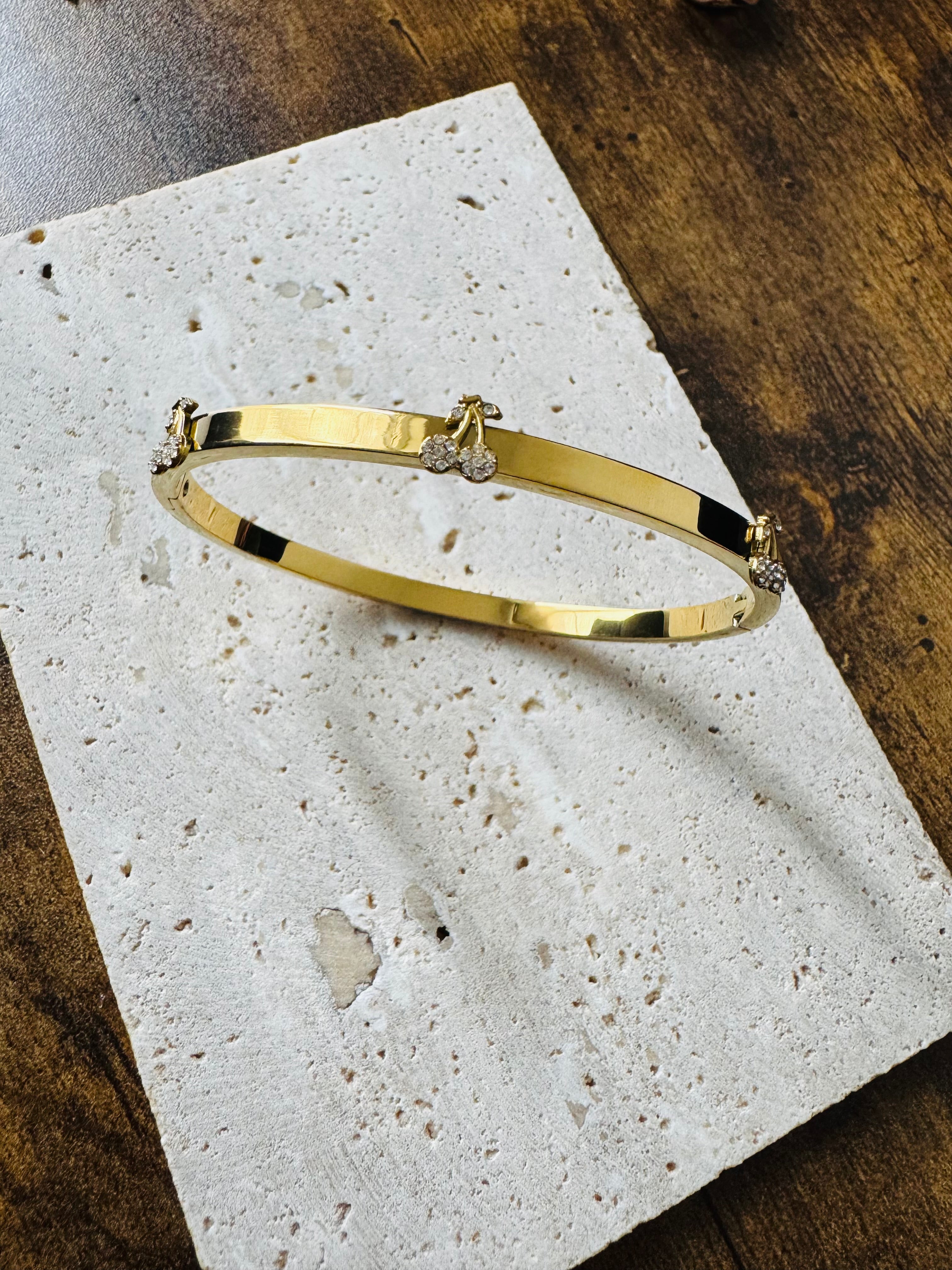 Vergoldeter Damenarmreif mit kirschroten Akzenten und funkelnden Zirkonia-Steinen von Finesse Feminine Jewelry