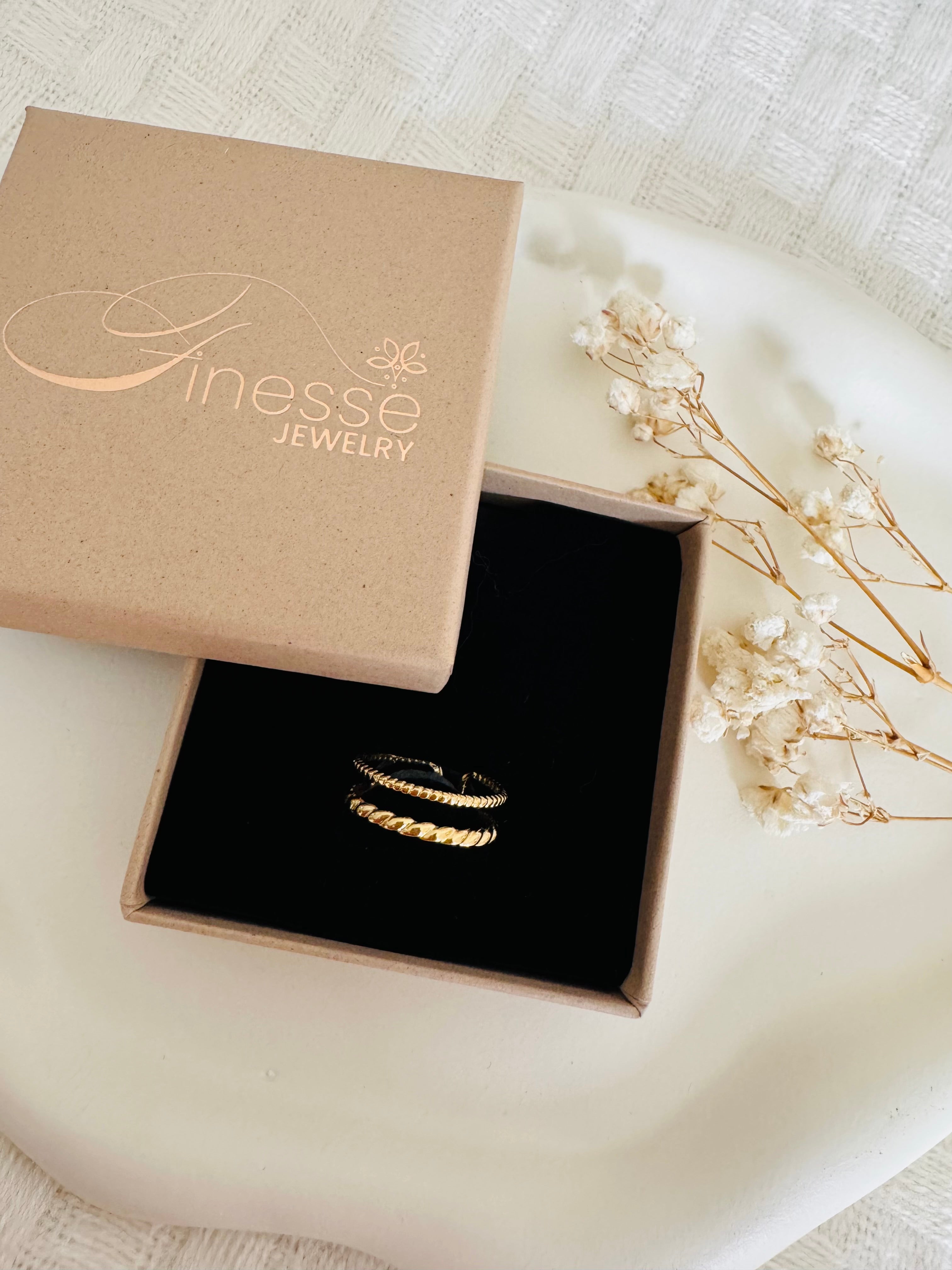 Vergoldeter Damenring mit elegant gedrehtem Design und funkelnden Zirkonia-Steinen von Finesse Feminine Jewelry